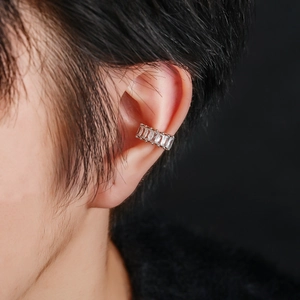 Gros plan d'un earcuff en argent serti de zircons rectangulaires porté par un mannequin