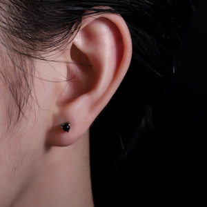 Detailed close-up of a dragon claw stud earring with a 5mm black zircon stone on ear
