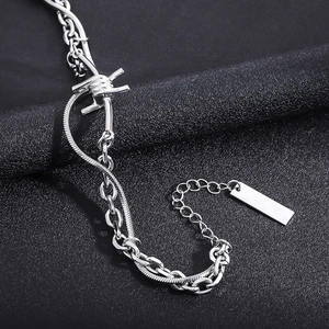 Detail view of double layer punk chain bracelet with thorn charm and metal tag