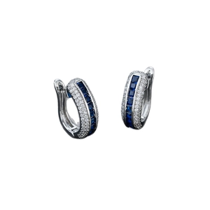 Silver hoop earrings with square blue zircon and white diamonds inlay on white backdrop