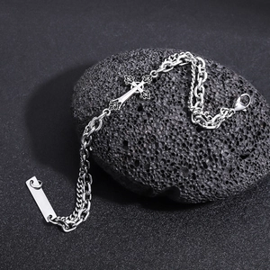 Détail du bracelet croix gothique en argent sur pierre volcanique avec chaîne double couche