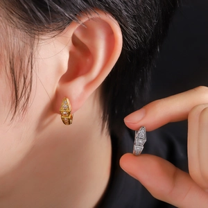 Close-up of geometric hoop earrings with sparkling cubic zirconia in gold and silver