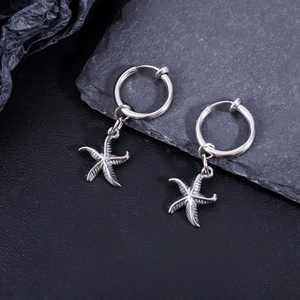 Dettaglio di orecchini a cerchio in acciaio argento con pendenti a forma di stella marina