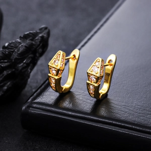 Macro detail of gold geometric hoop earrings with clear micro-pave zircons