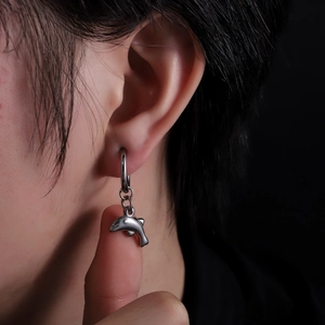 Détail d'une boucle d'oreille dauphin en acier sur mannequin au fini métallique