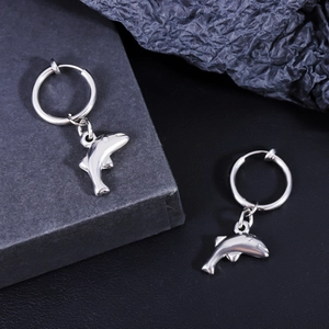 Détail d'une boucle d'oreille dauphin en acier inoxydable poli sur boîte cadeau noire