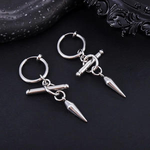 Gros plan détaillé des boucles d'oreilles punk en acier inoxydable sur fond de cuir noir