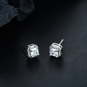 Close-up of square zircon stud earrings with halo setting and four-prong design
