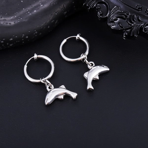 Vue macro de boucles d'oreilles pendantes dauphin en acier poli sur fond noir