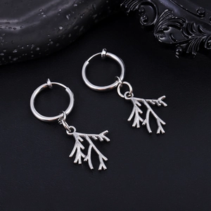 Macro shot of silver stainless steel leaf earring charms with natural branch texture