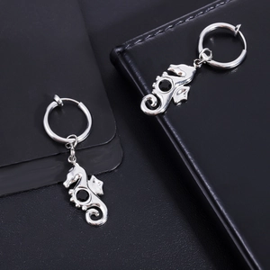 Detailed macro view of silver seahorse hoop earrings with black zircon stones