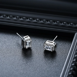 Macro shot of silver emerald-cut cubic zirconia stud earrings with halo setting and silver posts