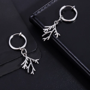Detailed close-up of silver branch pendants on black leather, showing polished steel texture
