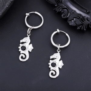 Detail view of seahorse earrings in silver steel with black stone on leather