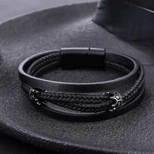 Macro detail of triple-layer black leather bracelet with crown beads and magnetic clasp