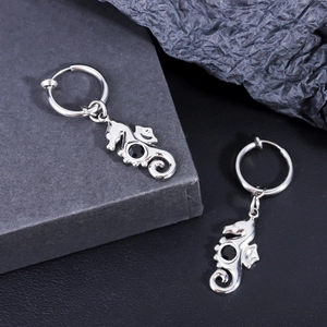 Macro shot of seahorse-shaped stainless steel earrings with black gemstone inlay
