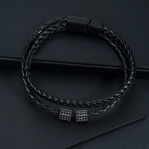 Macro detail of multi-strand braided leather bracelet with matte black magnetic buckle