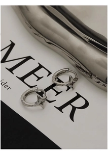 Detailed view of silver star hoop earrings with high-polish metallic finish and secure clasp