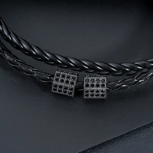 Close-up of black braided leather bracelet with twin micro-pave black zircon charms
