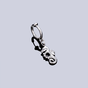 Silver stainless steel seahorse hoop earring with a black gemstone accent on dark background