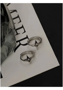 Detailed macro view of S925 sterling silver star pendant hoop earrings on minimalist background