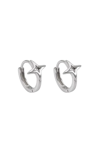 Macro detail of silver hoop earrings featuring minimalist four-point star cutout designs