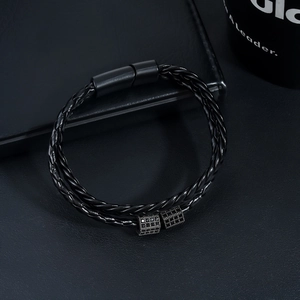 Detail of black double-layered braided leather bracelet with pavé-set magnetic clasp
