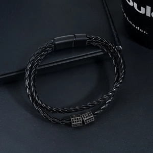 Macro shot of black braided leather bracelet with matte magnetic clasp and metal beads