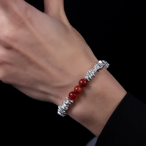 Handmade beaded bracelet with silver spiral metal accents and red agate gemstones