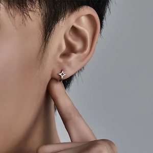 Polished silver star hoop earring on male model showing minimalist four-pointed design