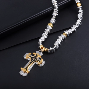 Vue macro d'un pendentif croix superposé argent et or avec émail noir sur sa chaîne