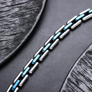Detailed close-up of a silver stainless steel Cuban link bracelet with blue accents