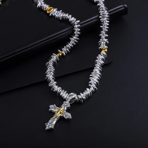 Close-up of retro double-layer cross pendant with Peace engraving and silver beaded chain