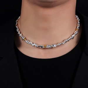Detailed view of beaded necklace with irregular silver and gold metallic beads on black clothing