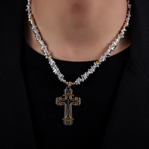 Collier rétro avec pendentif croix, perles argentées et détails dorés porté par un modèle