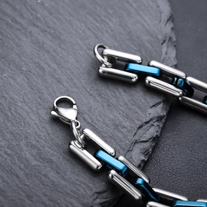 Close-up of a two-tone silver and blue Cuban link bracelet with a lobster clasp