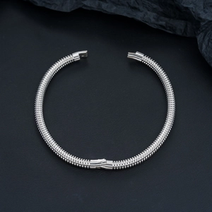 Detailed macro view of silver stainless steel cuff with 3D pyramid stud texture