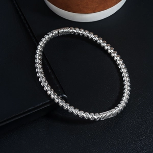 Detailed view of silver threaded beads on a minimalist stainless steel bangle