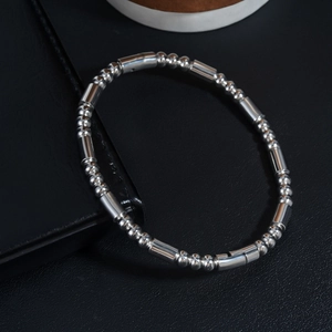 Gros plan du bracelet en acier inoxydable poli avec perles sur cuir noir