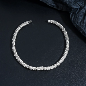 Detailed macro view of silver open choker featuring geometric textured carvings