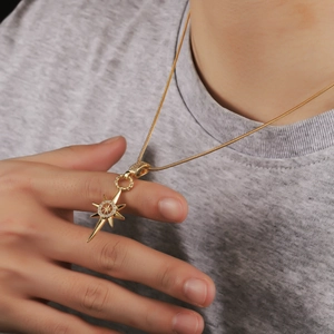 Detail of model wearing a gold eight-pointed star necklace with sparkling crystals