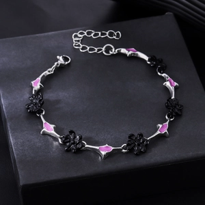 Detail of flower bracelet featuring black floral motifs and pink enamel geometric links