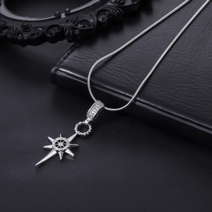 Macro shot of silver eight-pointed star pendant with inlaid diamonds on a snake chain
