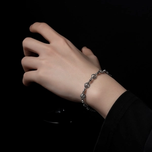 Bracelet chaîne argenté minimaliste avec sphères métalliques texturées porté au poignet