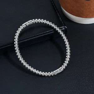 Macro detail of silver stainless steel beaded bracelet with textured spiral pattern links
