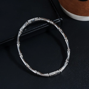 Macro shot of silver bamboo joint textured stainless steel bracelet on leather