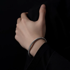 Detailed view of silver threaded beads on a sleek stainless steel bracelet for men and women