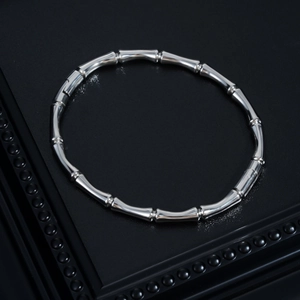 Detailed top view of a silver bamboo joint bracelet with a polished mirror finish on black