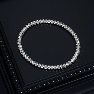 Close-up of a silver stainless steel bangle featuring a detailed spiral threaded texture