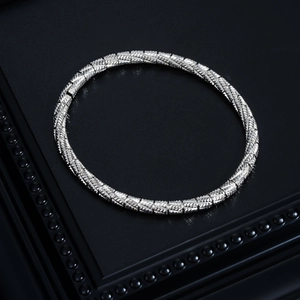 Detail of silver stainless steel bracelet featuring intricate woven vein textures